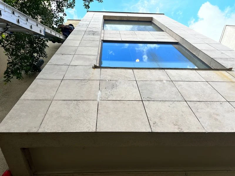 Close view of stucco panels, joints and window transitions on a building exterior