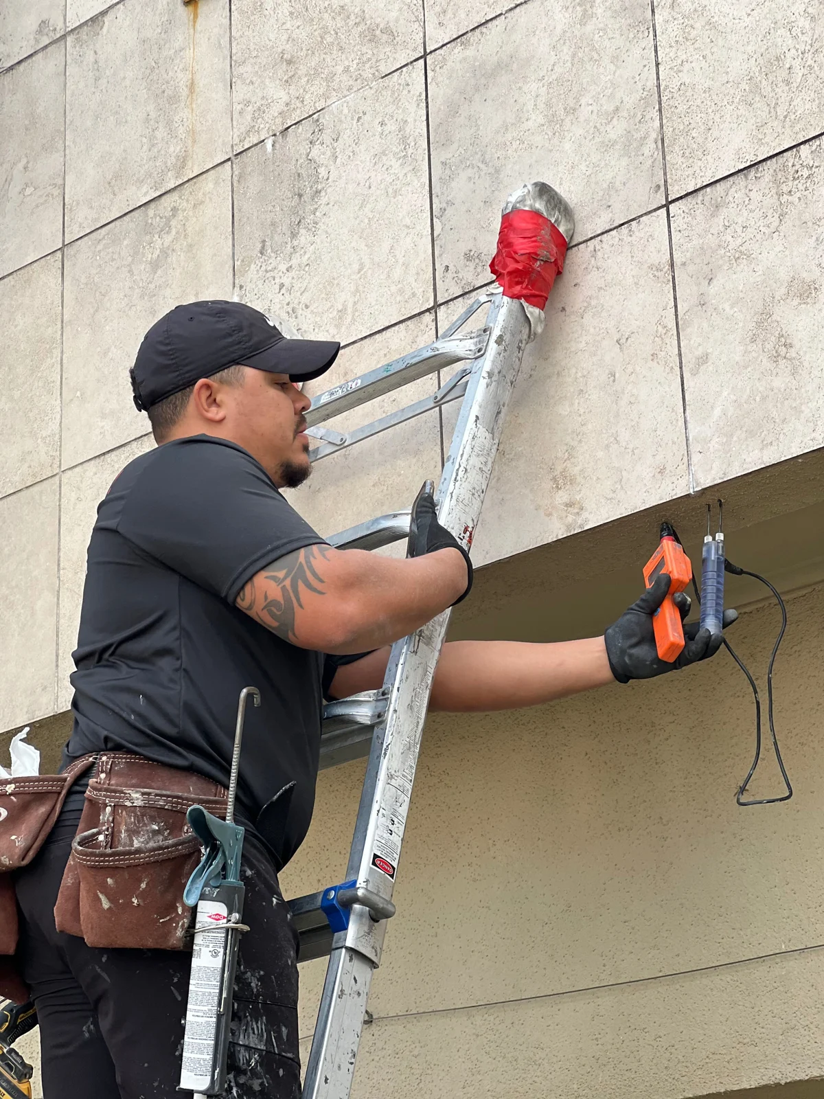 Stucco Check inspector using a moisture meter and probes at an exterior wall