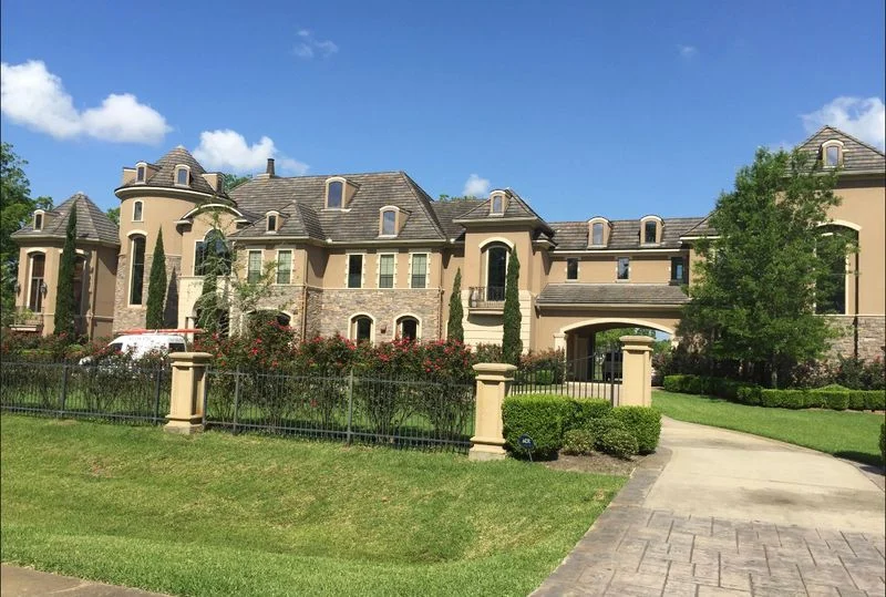 Stucco home with arched windows and a landscaped front entrance from the Stucco Check photo library